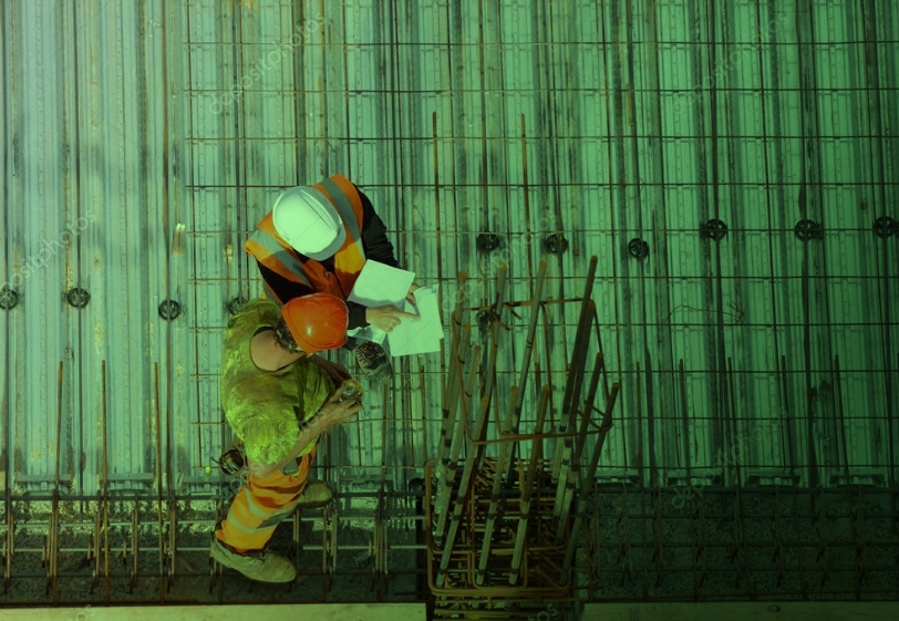 Operaio con caschetto arancione controlla armatura