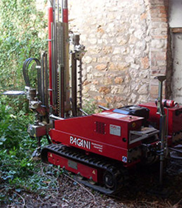 Piccola sonda geotecnica rossa vicino a
edificio in pietra