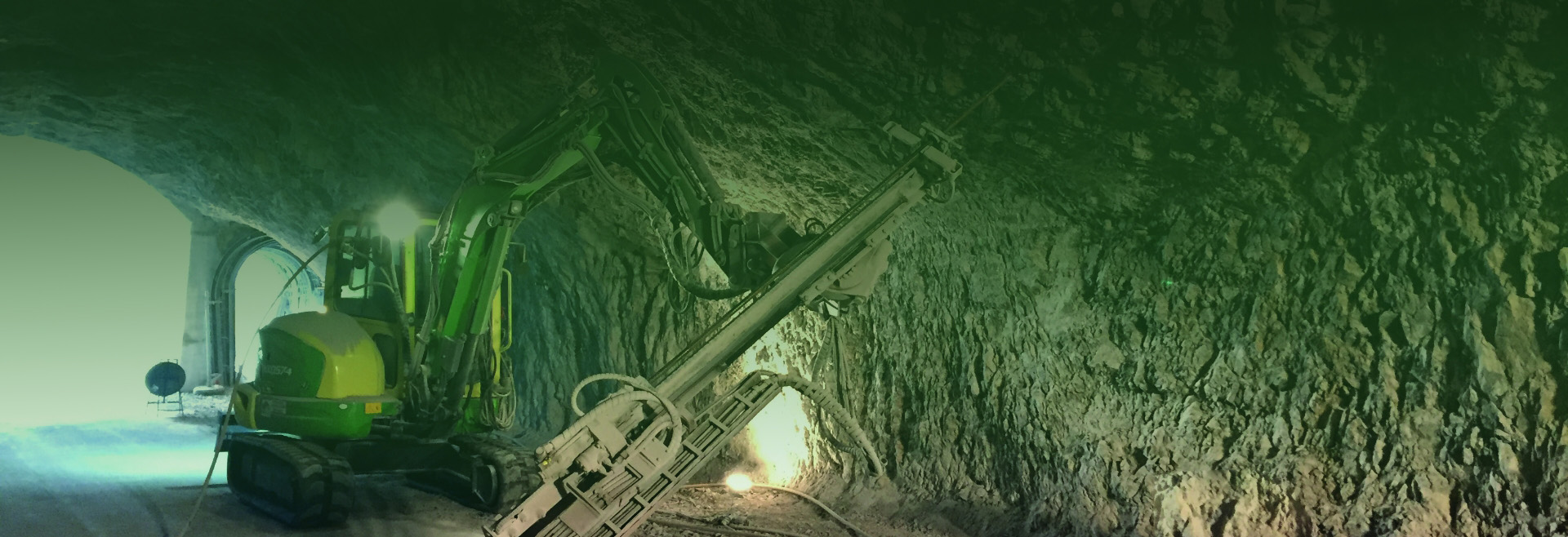 Escavatore con perforatrice opera in galleria sotterranea