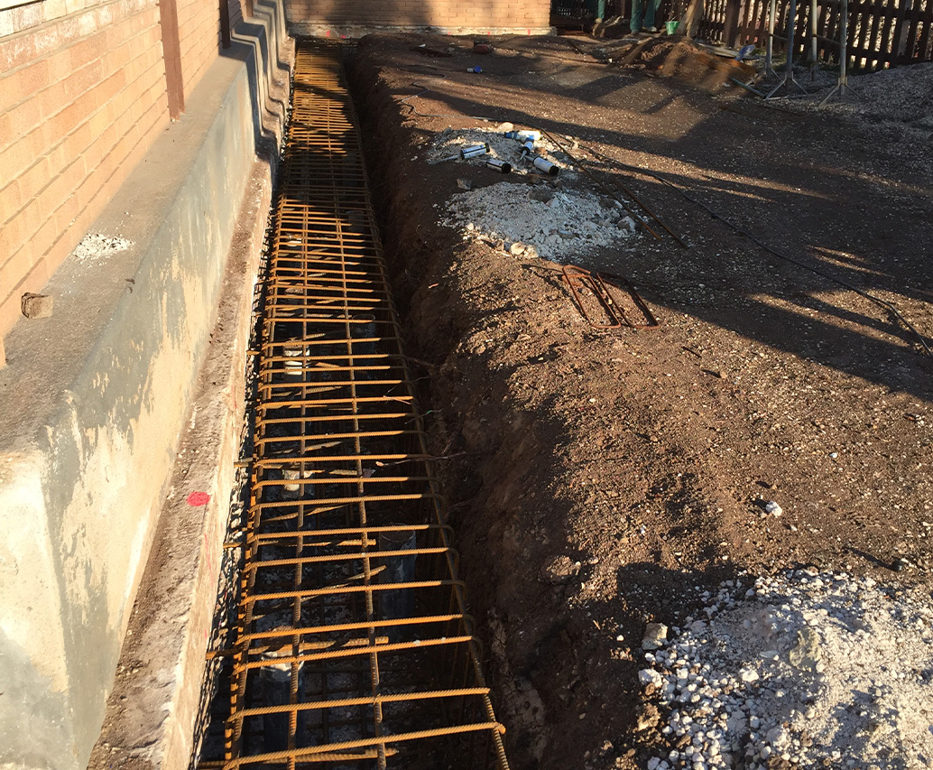 Perforatrice verde al lavoro vicino a edificio