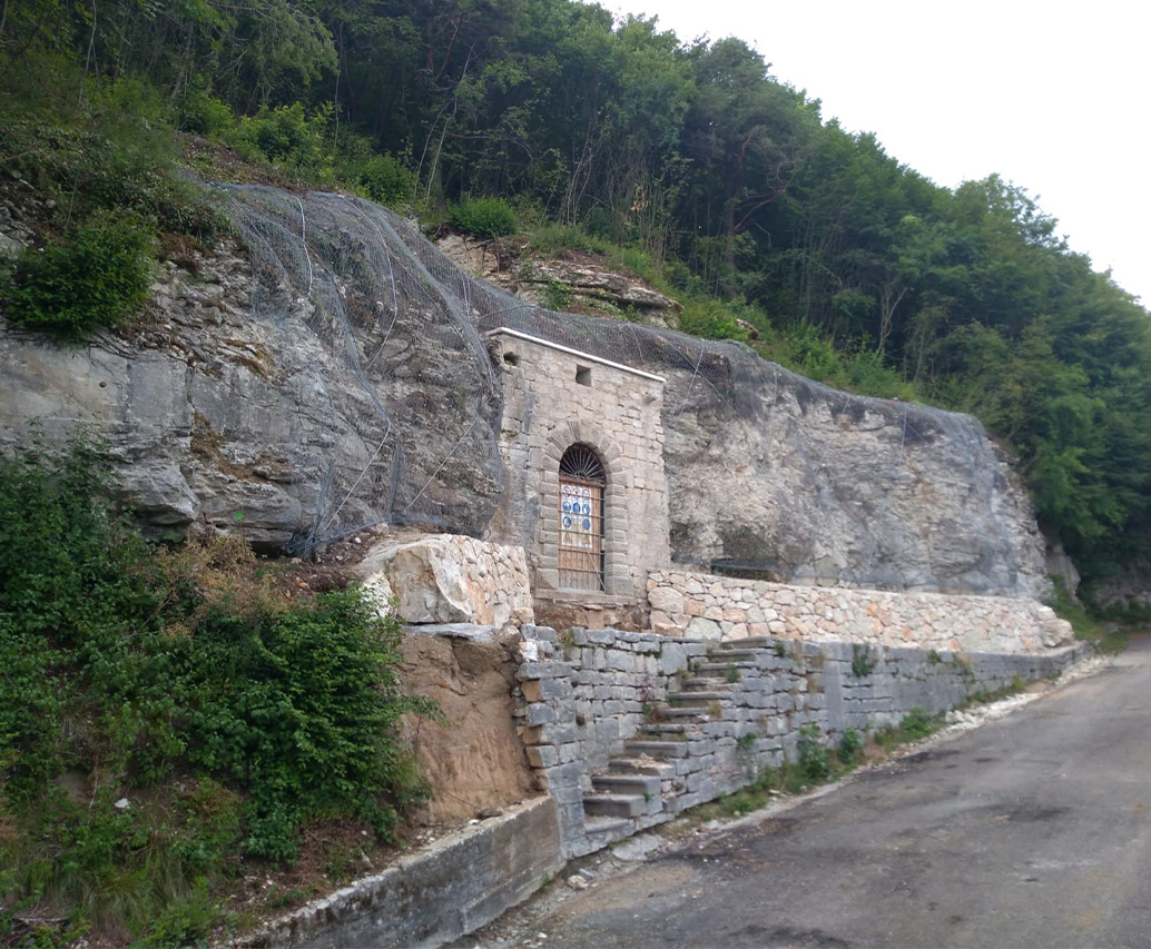 Parete di roccia con rete paramassi e passerella