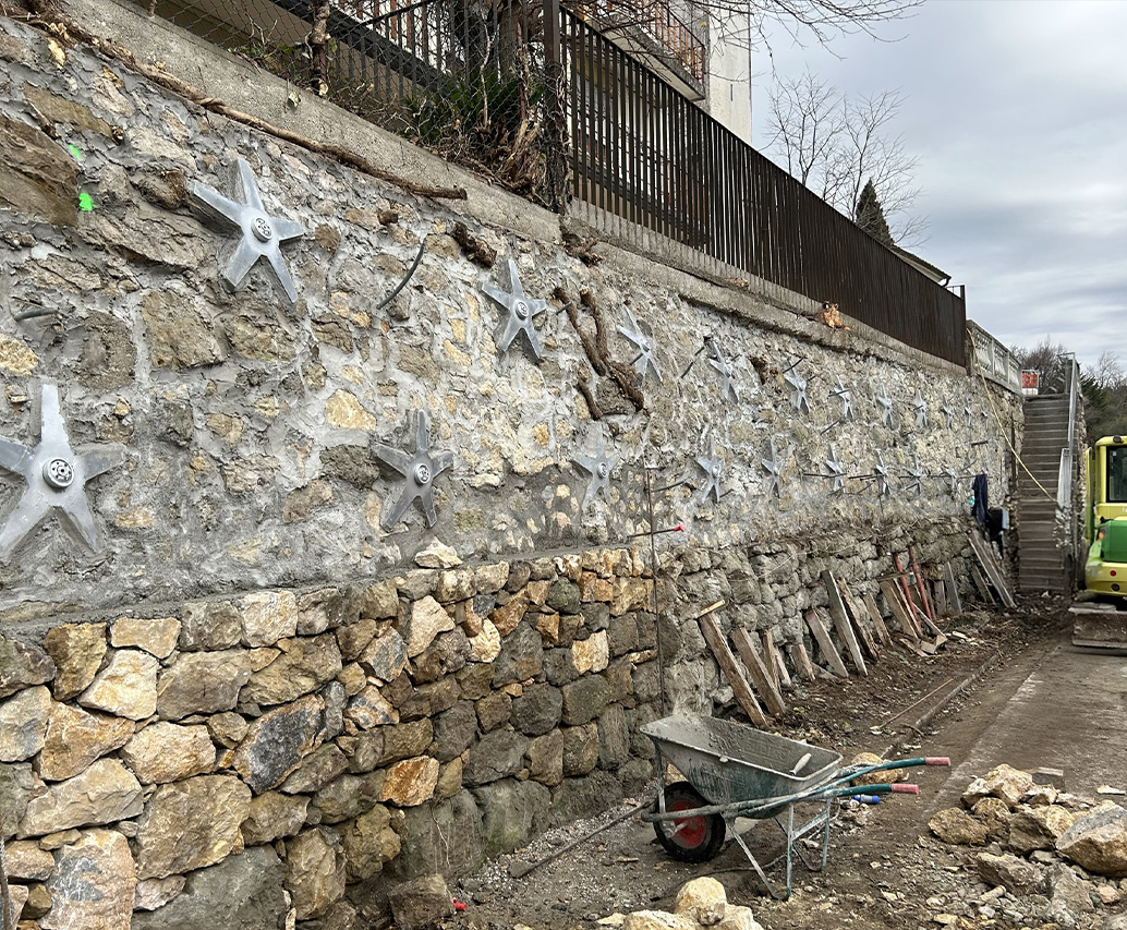 Muro in pietra con ancoraggi a stella e ponteggio