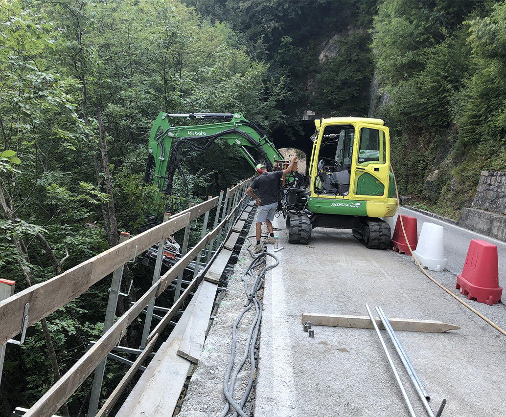Passerella lungo canale con escavatore