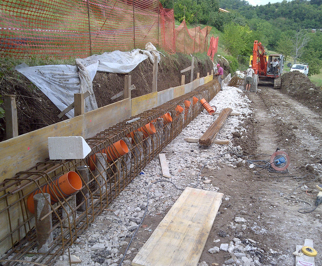 Cantiere con posa di drenaggi e tiranti in scavo