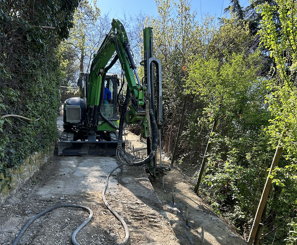 Macchina perforatrice verde su pendio stradale
