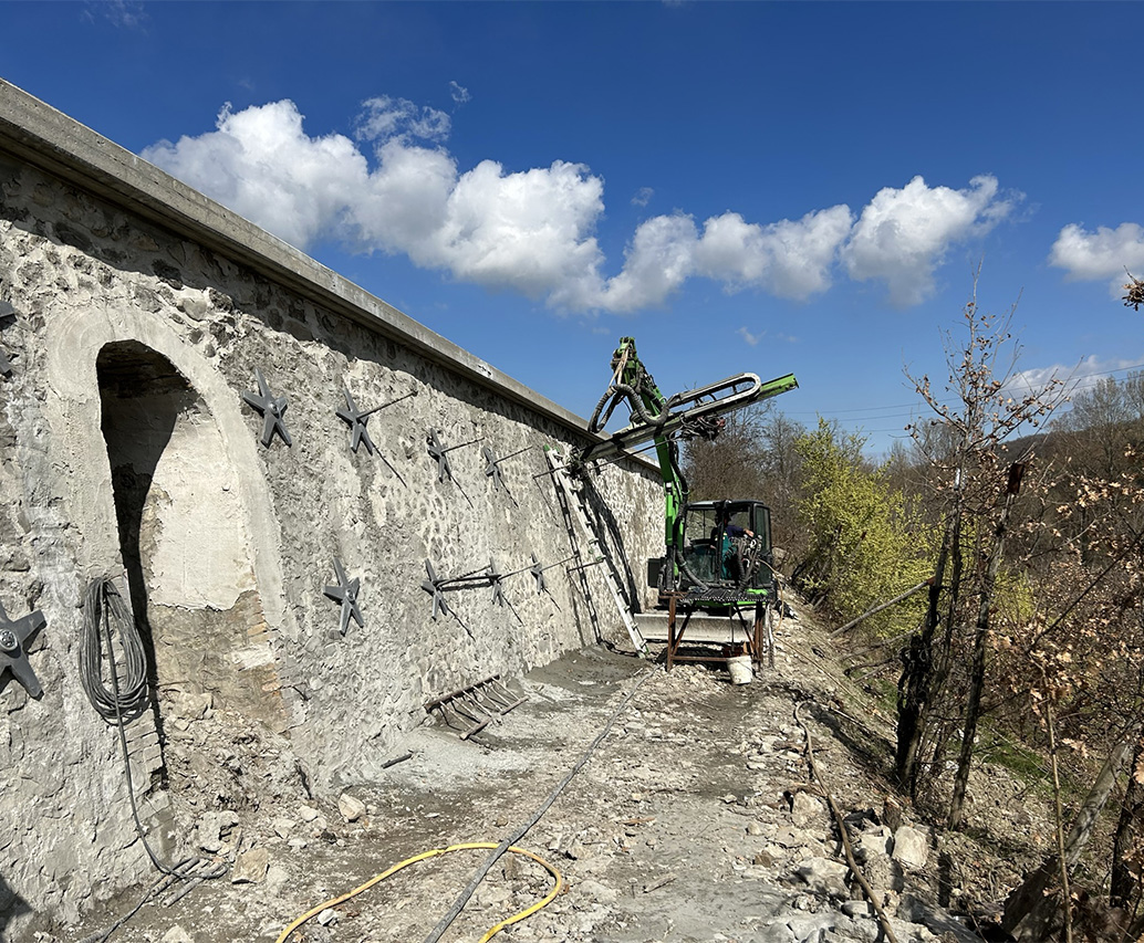 Escavatore perfora muro in pietra