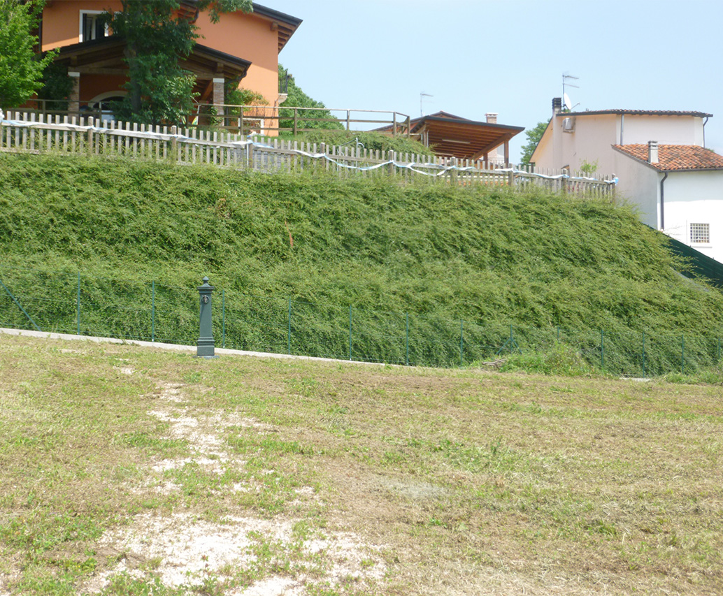 Bordo strada con scarpata erbosa e vallata
