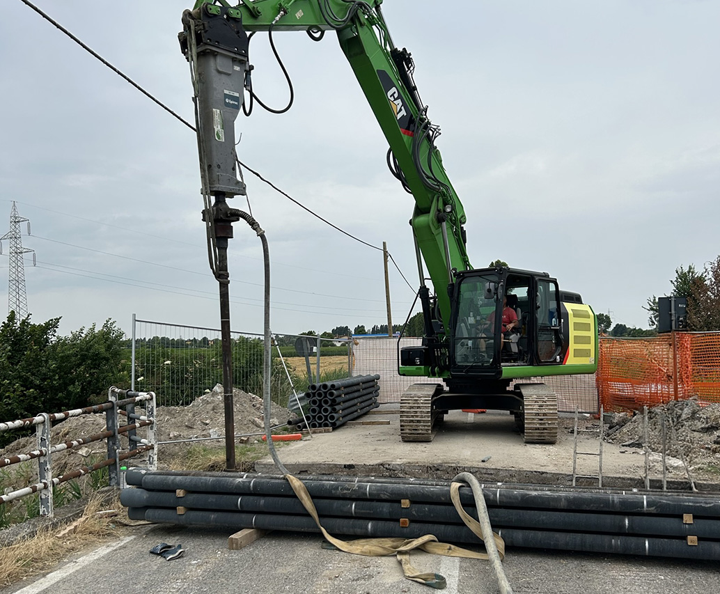 Escavatore installa pali in ghisa