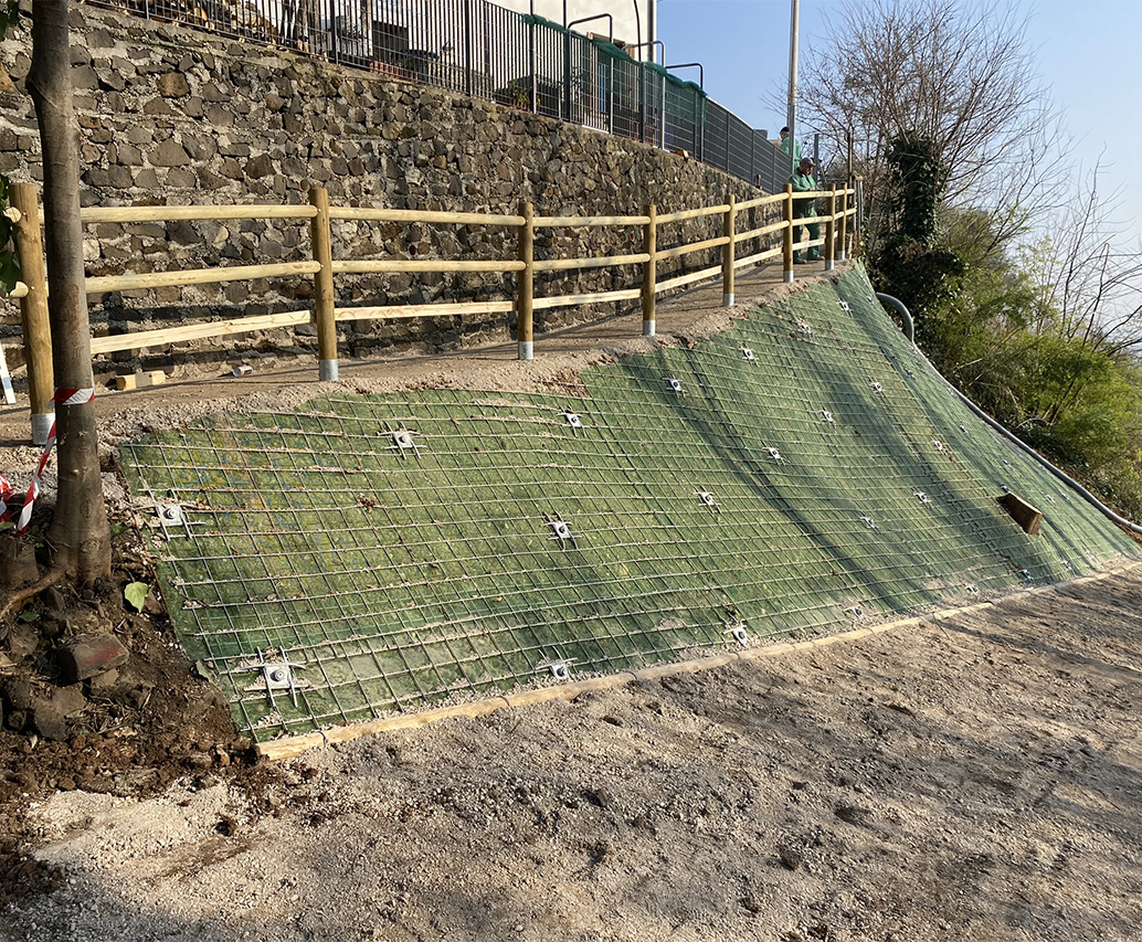 Dettaglio maglia metallica su parete verde