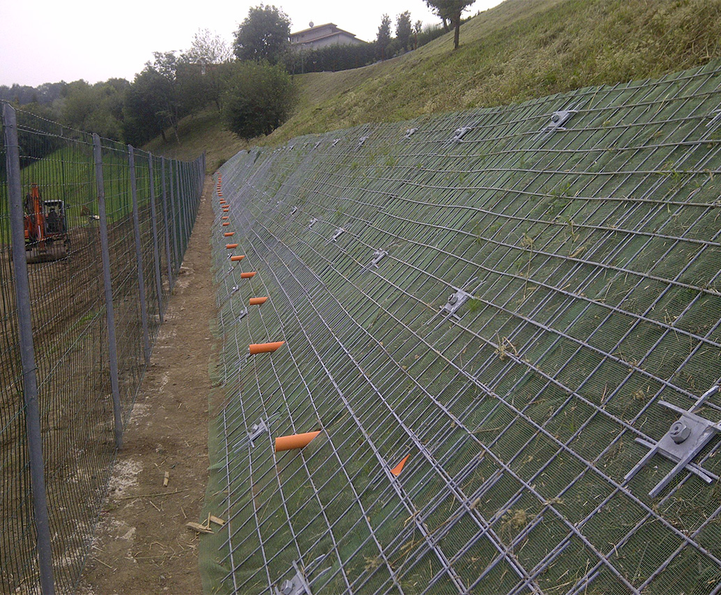 Pendio rinforzato con rete metallica e vegetazione