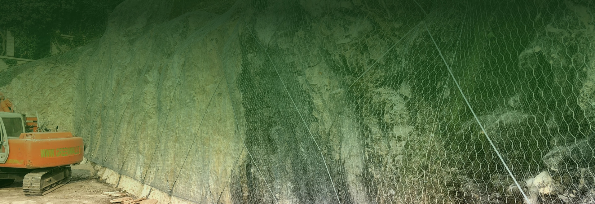 Pendio con rete paramassi e escavatore