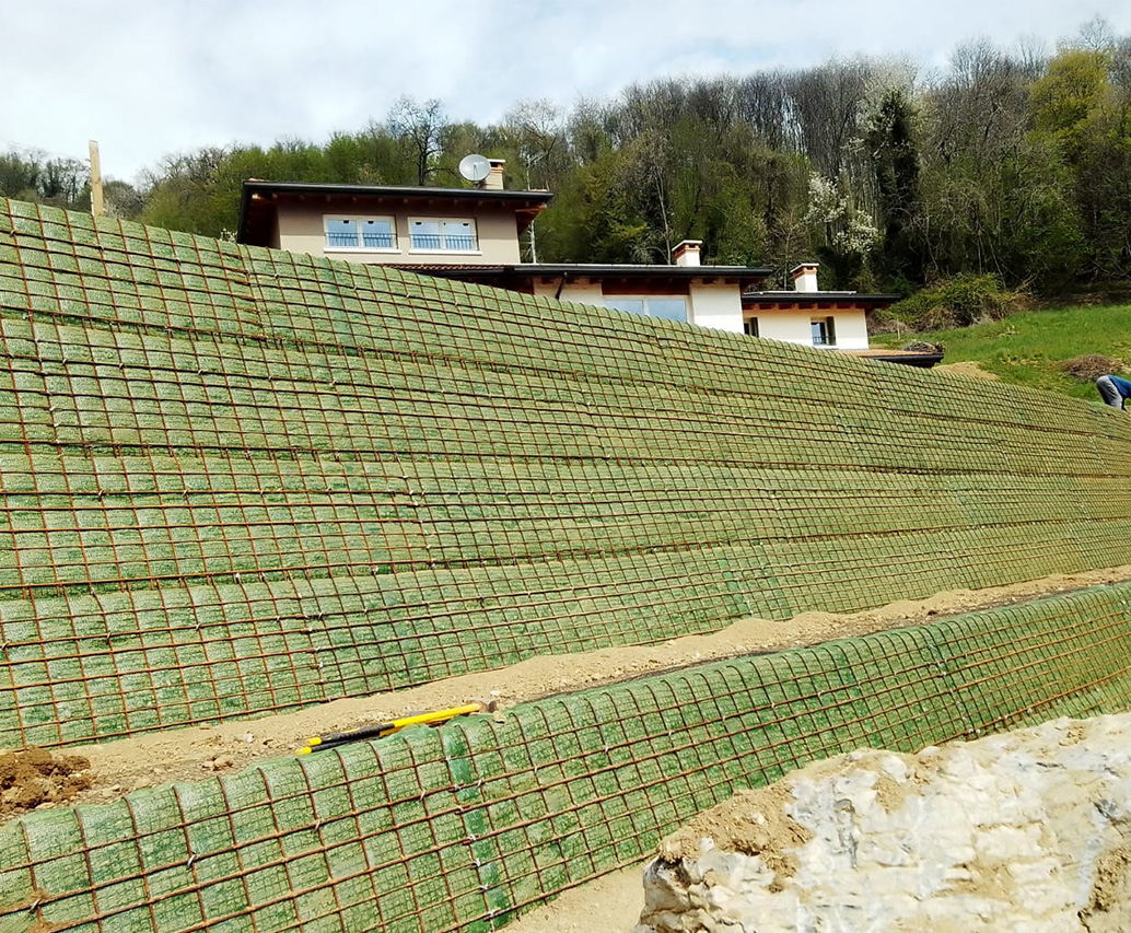 Escavatore giallo su scarpata rinforzata