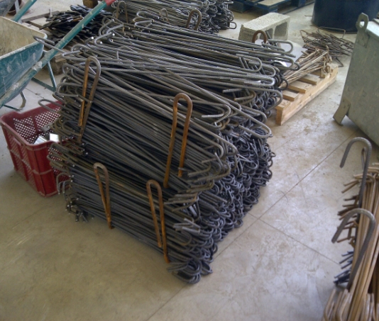 Tiranti in acciaio e ganci impilati su pallet